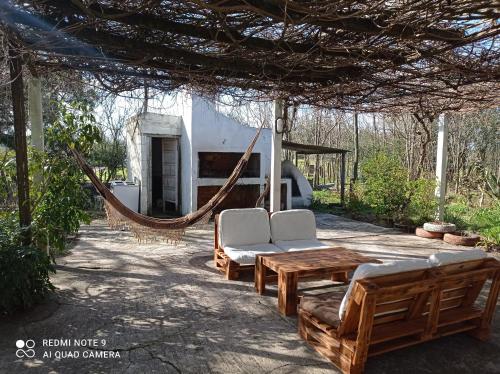 um pátio com uma rede de descanso e cadeiras e uma casa em POSADA em Minas