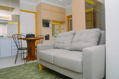 a living room with a couch and a kitchen at Modern Studio at Titanium Square Apartment By Travelio in Jakarta