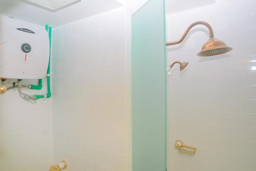 a shower in a bathroom with a light and a shower at Modern Studio at Titanium Square Apartment By Travelio in Jakarta