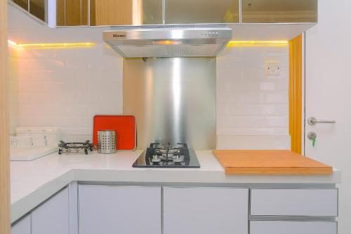 a kitchen with a stove top oven in a kitchen at Modern Studio at Titanium Square Apartment By Travelio in Jakarta