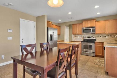 a kitchen with a wooden table and chairs and a kitchen with stainless steel appliances at Adventure Home Rentals in Phoenix