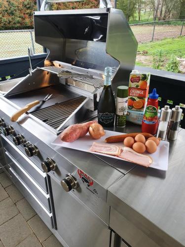 a barbecue grill with meat and eggs on a counter at The Lancefield Lodge in Lancefield