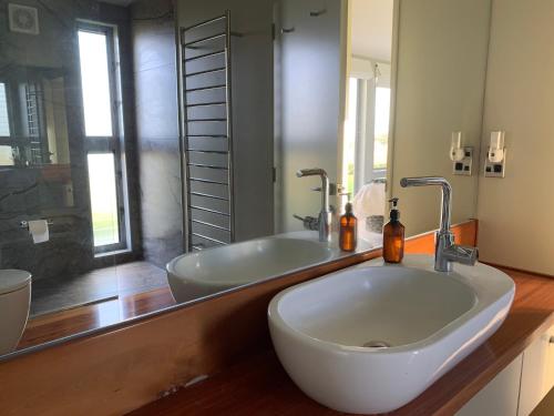 a bathroom with two sinks and a large mirror at Mangawhai Bay B&B in Omokoroa