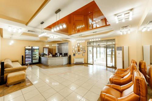 a large lobby with leather chairs and a kitchen at Hotel Briz in Orenburg