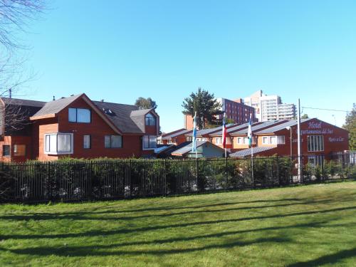 a group of houses behind a fence in a yard at Hotel Departamentos del Sur in Puerto Montt