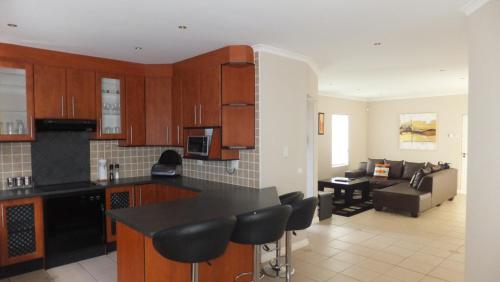 a kitchen and living room with a counter and a couch at B.R.O.Homes and Villas in Port Elizabeth
