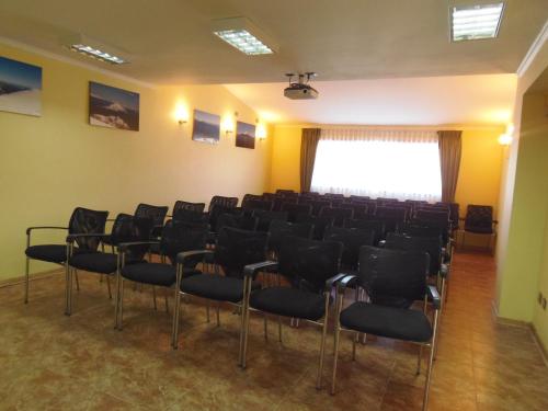a conference room with chairs and a large window at Hotel Departamentos del Sur in Puerto Montt