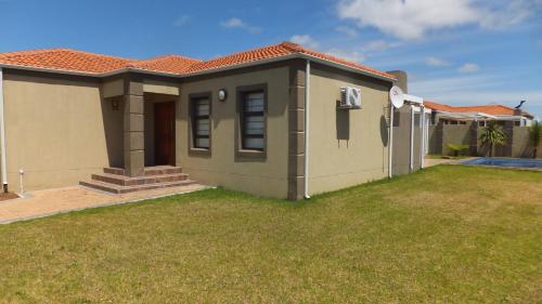 a small house with a lawn in front of it at B.R.O.Homes and Villas in Port Elizabeth