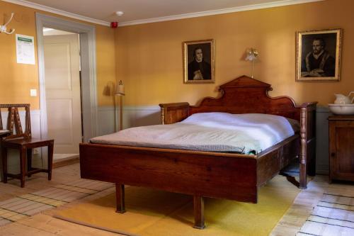 a bedroom with a wooden bed in a room at Vandrarhemmet Årås Säteri och Trädgårdar in Årås