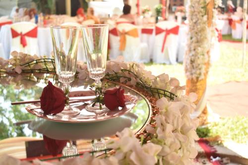 a table with two wine glasses and roses on it at Leinmach House Nyali in Mombasa