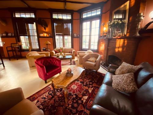 sala de estar con sofá, sillas y mesa en Old Mine Guesthouse, en Musina