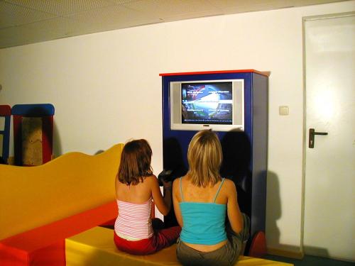 two girls sitting in front of a video game at Appartement Pension Auhof in Going