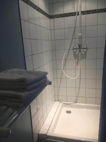 y baño con ducha, lavabo y toallas. en L'Atelier du Pont de Mars en Mars