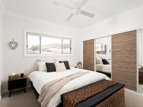 a bedroom with a large bed and a window at Calm at Shoal Bay in Shoal Bay