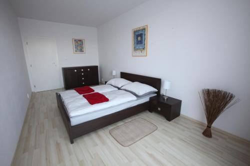 a bedroom with a bed with white sheets and red blankets at Apartment Park Radouč - 60m2 in Mladá Boleslav