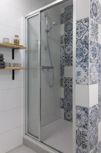 a shower with a glass door in a bathroom at INITIUM rooms - Pokoje na wynajem - Obrońców Wybrzeża 4D in Gdańsk