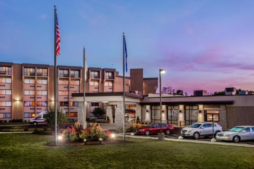 a building with cars parked in a parking lot at Crowne Plaza Milwaukee Airport by IHG in Milwaukee