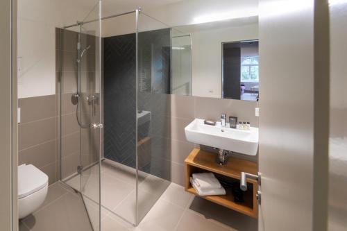 a bathroom with a shower and a sink at Brera Leipzig in Leipzig
