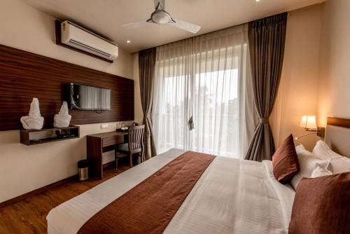 a hotel room with a bed and a window at The Green Boutique in Panaji