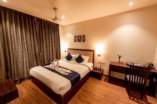 a bedroom with a bed and a desk in a room at The Green Boutique in Panaji