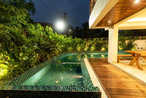 a swimming pool next to a house at night at The Green Boutique in Panaji