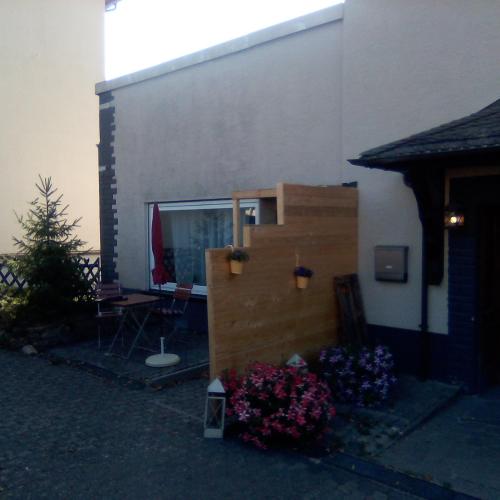 a house with a staircase and flowers in a yard at Ferienappartement Studio " Michel" Otzenhausen in Nonnweiler