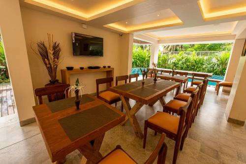 a dining room with wooden tables and chairs at The Green Boutique in Panaji