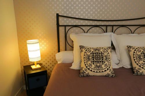 a bedroom with a bed with pillows and a lamp at Superbe appartement tout confort "Le Séquoia" in Monchy-Saint-Éloi