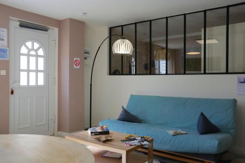 a living room with a blue couch and a table at Superbe appartement tout confort "Le Séquoia" in Monchy-Saint-Éloi