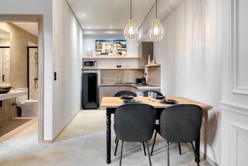a kitchen and dining room with a wooden table and chairs at Muse Urban Suites in Athens