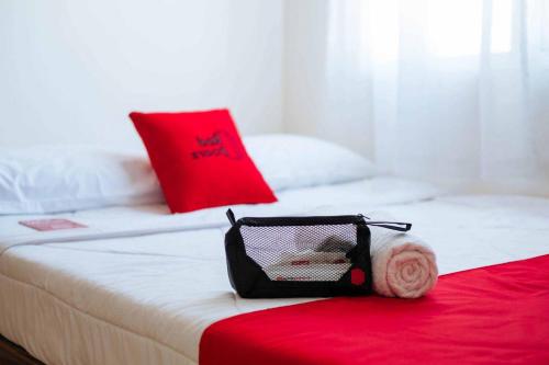 a bag sitting on top of a bed at RedDoorz Syariah @ Sunan Bonang Magelang in Magelang
