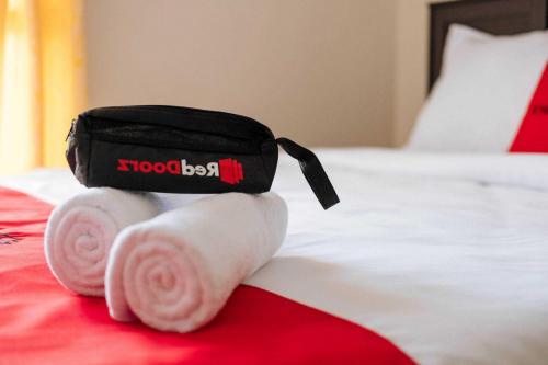 a stuffed animal with towels and a bag on a bed at RedDoorz Syariah @ Sunan Bonang Magelang in Magelang