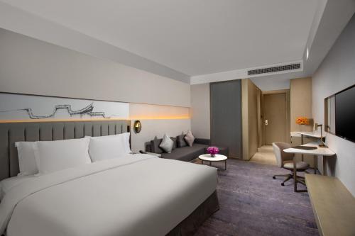 a hotel room with a large bed and a living room at Crowne Plaza Fuzhou South, an IHG Hotel in Fuzhou
