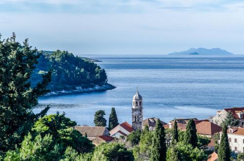 a town with a clock tower next to a body of water at Apartments Rilovic, City and Sea view apartments in Cavtat