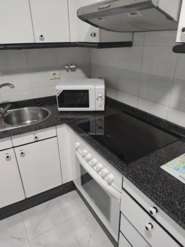 cocina con fregadero y microondas en Apartamento Julia en Vilagarcía de Arousa