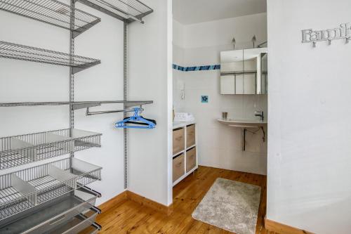 a kitchen with white walls and metal shelves at La Régate - Maison avec garage et jardin clos - Pléneuf in Pléneuf-Val-André
