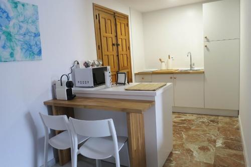 cocina con encimera, microondas y 2 sillas en Purísima Vivienda Turística, en Córdoba