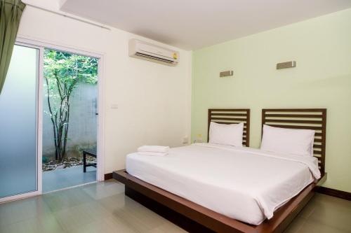 ein Schlafzimmer mit einem großen weißen Bett und einem Fenster in der Unterkunft S Hotel Kanchanaburi in Kanchanaburi