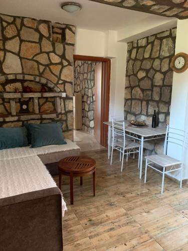 a living room with a couch and a table with chairs at Apartments Vuk in Lustica
