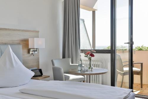 ein Hotelzimmer mit einem Bett, einem Tisch und Stühlen in der Unterkunft Arens Hotel 327mNN in Sankt Martin