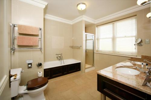 a bathroom with a toilet and a sink and a tub at Mount Falcon Estate in Ballina