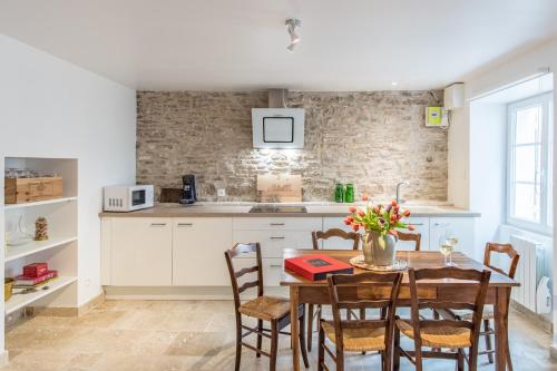 une cuisine avec une table en bois avec des chaises et un comptoir dans l'établissement Petit Montrachet, à Chassagne-Montrachet