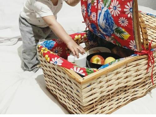 a child standing next to a basket of apples at Pouso do Rio in Pirenópolis