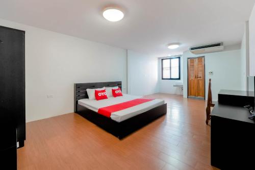 a bedroom with a bed with red pillows on it at OYO 935 The Palm Apartment in Bangkok