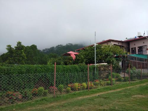 a fence in front of a garden with flowers at Samskara & Samsara in Lansdowne