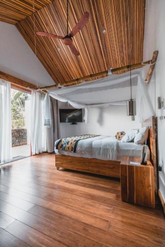 a bedroom with a bed and a ceiling fan at Hemingways Retreat Kigali in Kigali