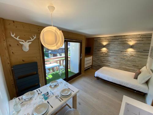a room with a bed and a table with dishes on it at Hôtel Rent in Megève