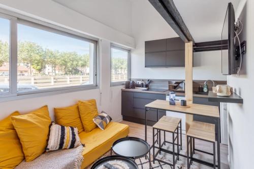 un salon avec un canapé et une cuisine dans l'établissement Duplex Sinèpe - Welkeys, à Trouville-sur-Mer