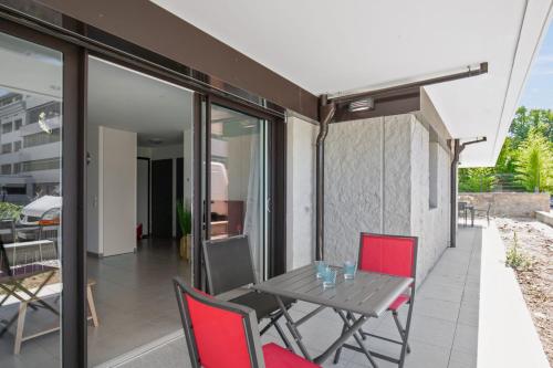 un patio avec une table et des chaises sur un balcon dans l'établissement Appartement Mavéria Welkeys, à Annecy