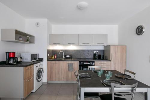 une cuisine avec une table et des chaises dans une cuisine dans l'établissement Appartement Mavéria Welkeys, à Annecy